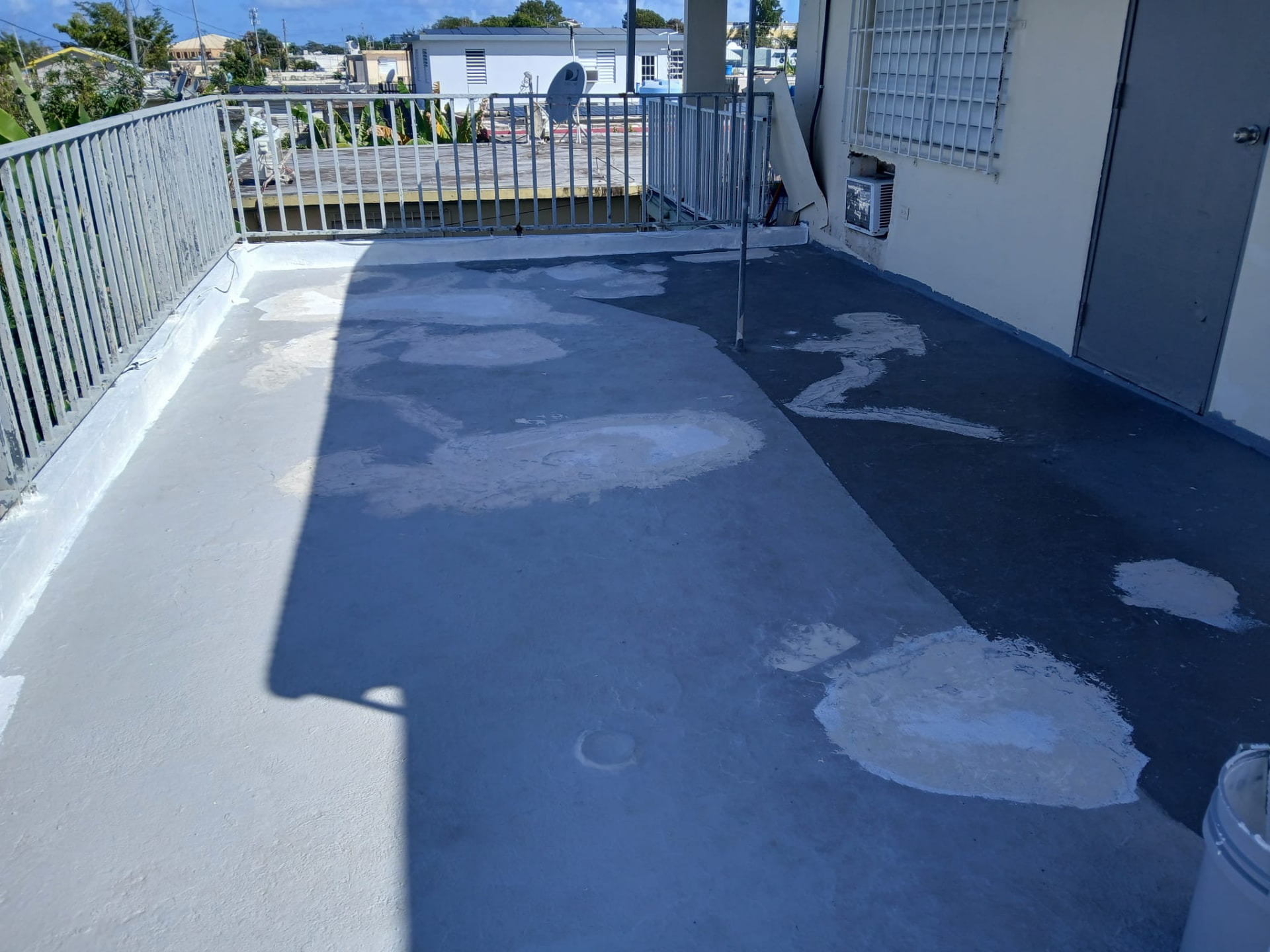 Terraza de techo en Puerto Rico antes del sellado, con parchos de sellador viejo y superficie despareja
