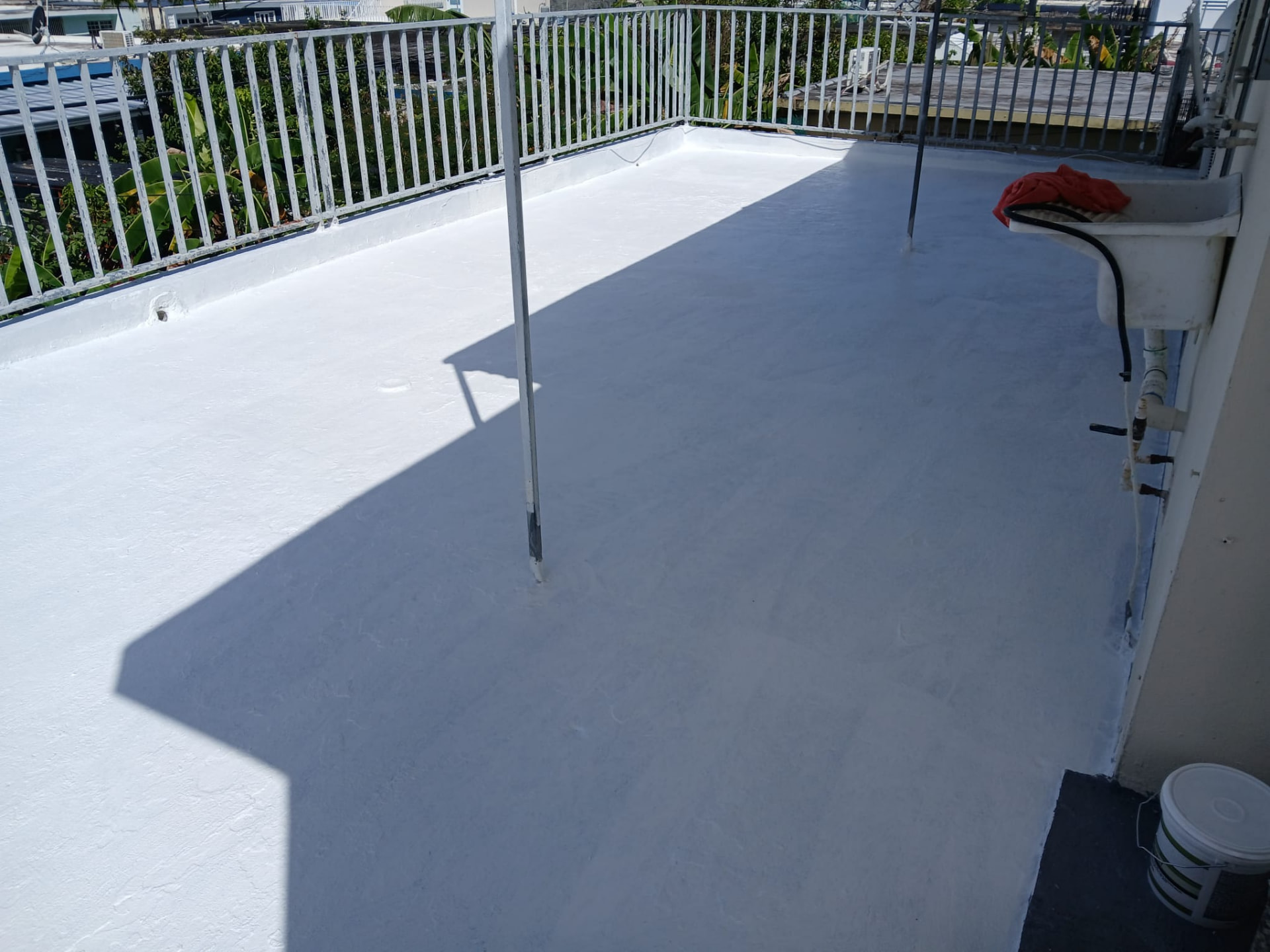 La misma terraza después del sellado elastomérico, con acabado blanco uniforme y parapetos sellados